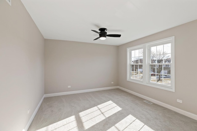 carpeted spare room featuring ceiling fan