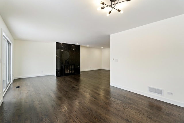 unfurnished living room featuring dark wood-type flooring and a high end fireplace