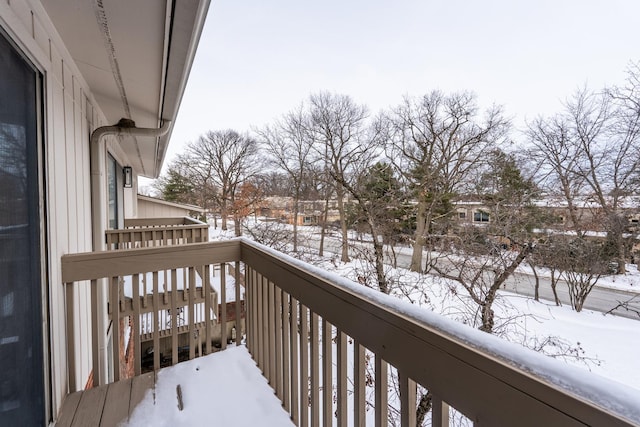 view of snow covered back of property