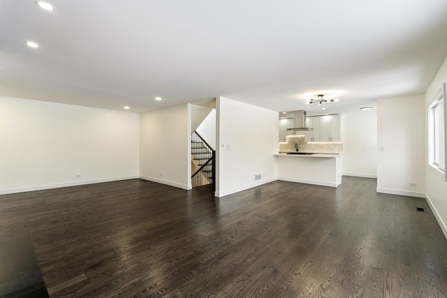 unfurnished living room with dark hardwood / wood-style flooring and sink