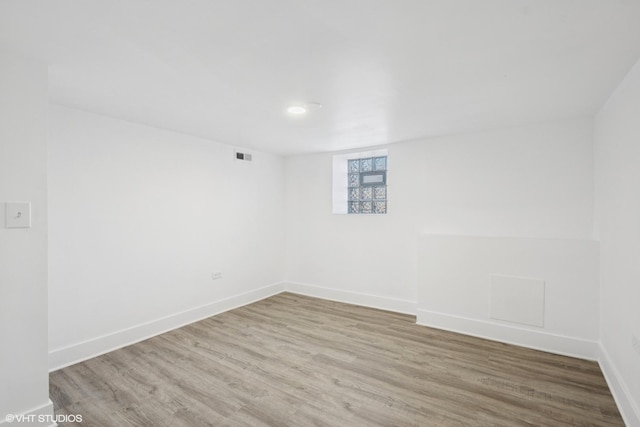 empty room featuring visible vents, baseboards, and wood finished floors