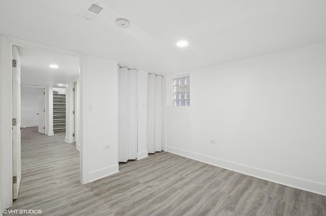 spare room with visible vents, baseboards, light wood-style flooring, stairs, and recessed lighting