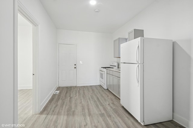 kitchen featuring white appliances, baseboards, light countertops, gray cabinets, and light wood finished floors