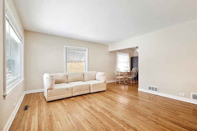 living area featuring hardwood / wood-style flooring, baseboards, and visible vents