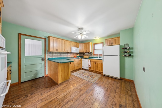 kitchen with white appliances, decorative backsplash, ceiling fan, hardwood / wood-style floors, and sink