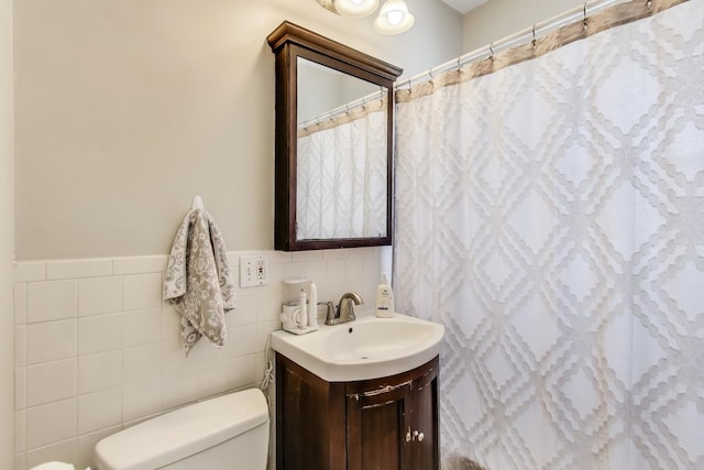 full bathroom with tile walls, a shower with shower curtain, vanity, and toilet