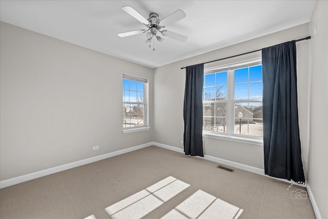 spare room featuring light carpet and ceiling fan