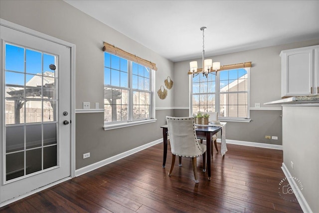 dining area with dark wood-type flooring and a chandelier