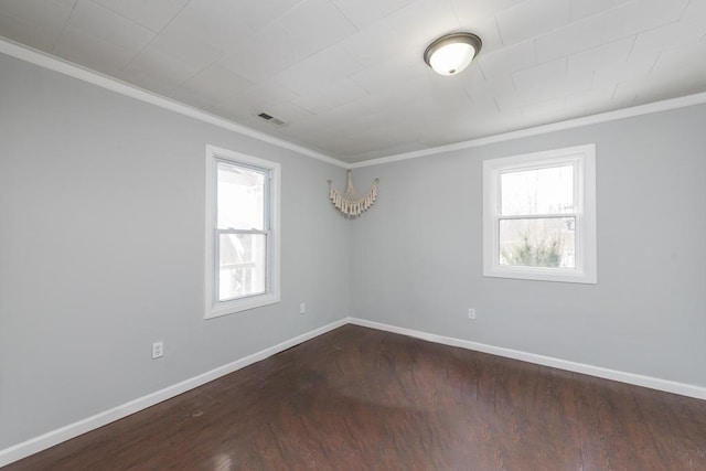 unfurnished room with dark wood-style floors, ornamental molding, visible vents, and baseboards