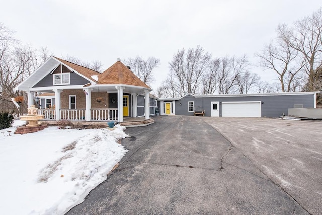 view of front of house with a garage, driveway, and a porch