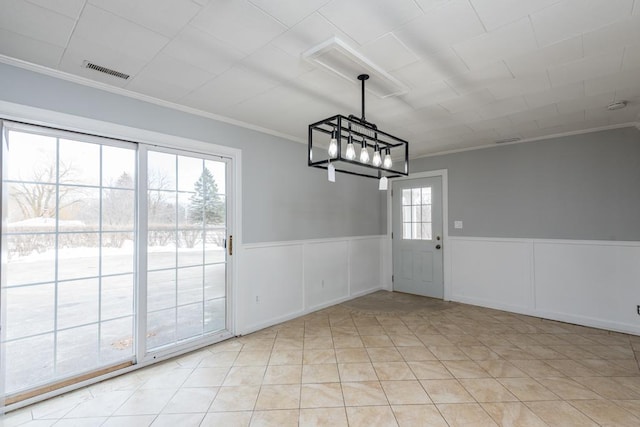 unfurnished dining area with a chandelier, light tile patterned flooring, visible vents, wainscoting, and crown molding