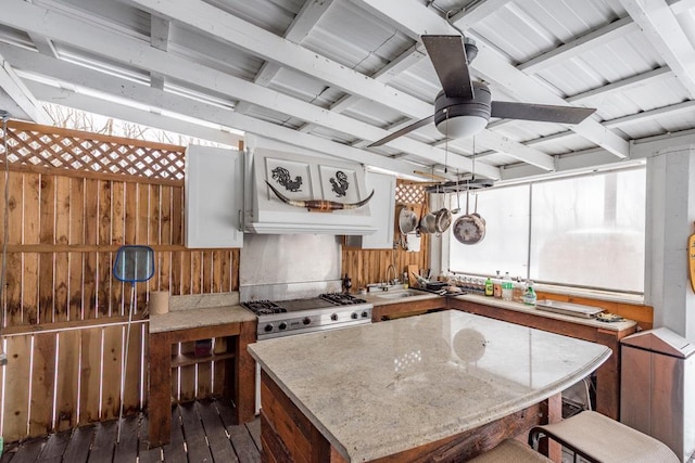 kitchen with dark wood-style floors, a center island, a ceiling fan, white cabinets, and range