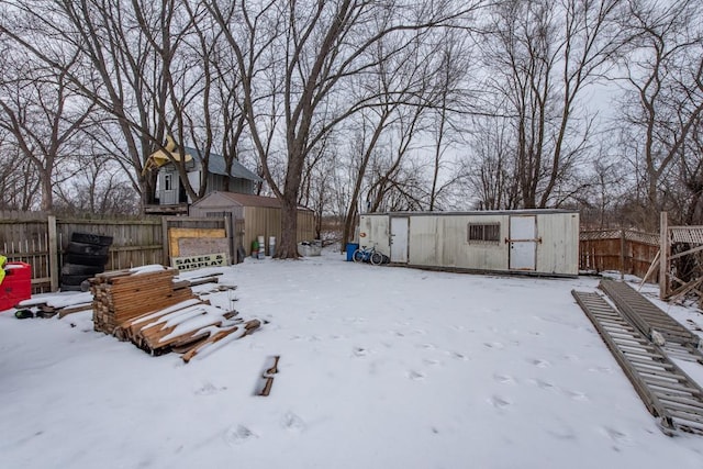 snowy yard featuring fence