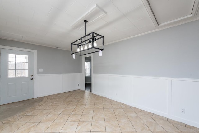 unfurnished dining area with a wainscoted wall and light tile patterned floors