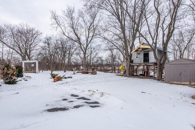 yard covered in snow featuring an outdoor structure and a storage shed