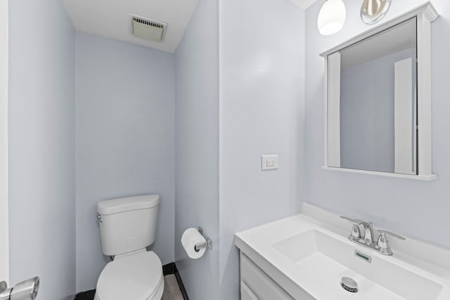 bathroom with visible vents, vanity, and toilet