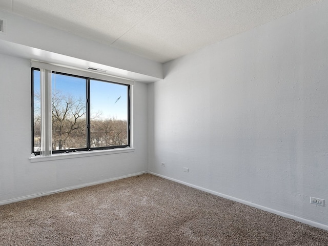 unfurnished room featuring a textured ceiling, carpet floors, visible vents, and baseboards