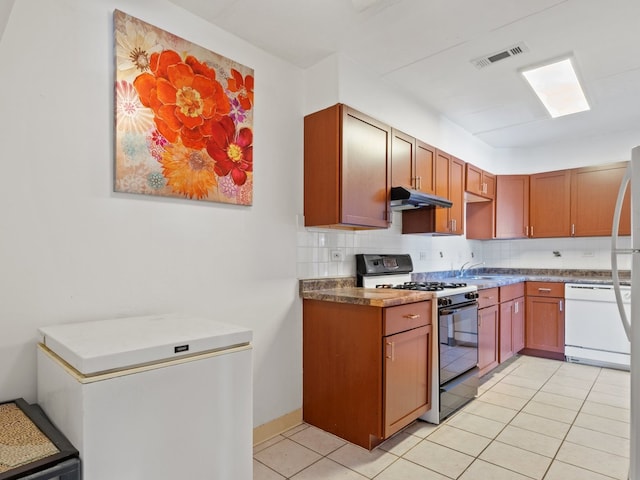 kitchen featuring visible vents, decorative backsplash, black range with gas stovetop, white dishwasher, and under cabinet range hood