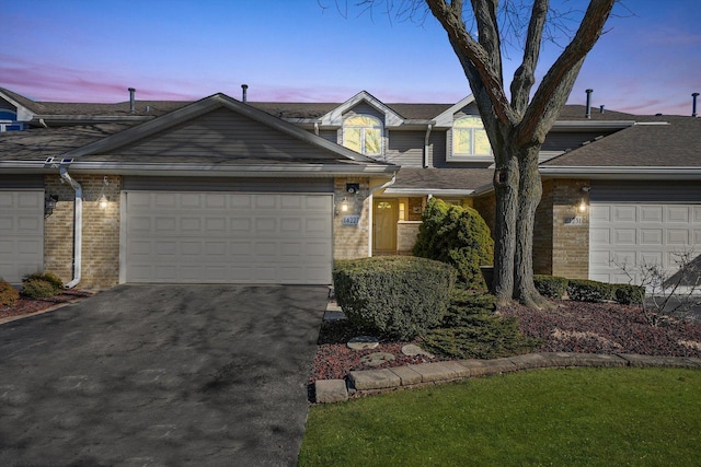 view of front of property featuring driveway, a garage, and brick siding