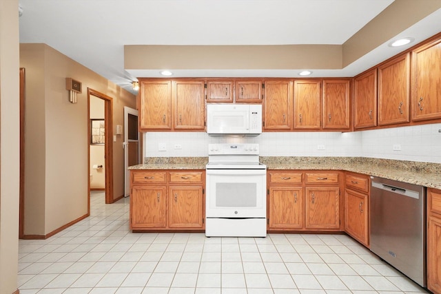 kitchen with tasteful backsplash, white appliances, and brown cabinetry