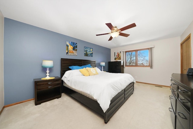 bedroom featuring baseboards, visible vents, a ceiling fan, and light colored carpet