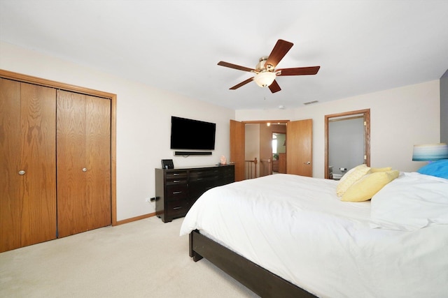 bedroom with light carpet, ceiling fan, visible vents, and baseboards