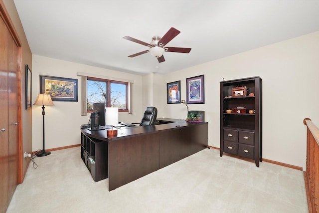 office area featuring baseboards, ceiling fan, and light colored carpet