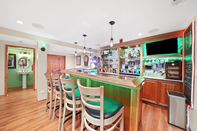 bar featuring visible vents, indoor bar, hanging light fixtures, light wood-type flooring, and recessed lighting