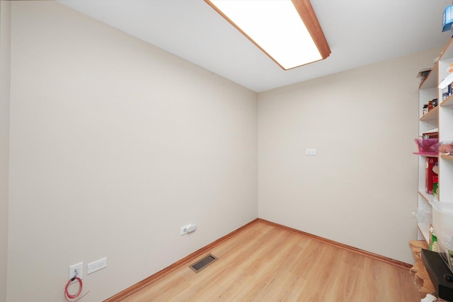 empty room with visible vents, baseboards, and wood finished floors