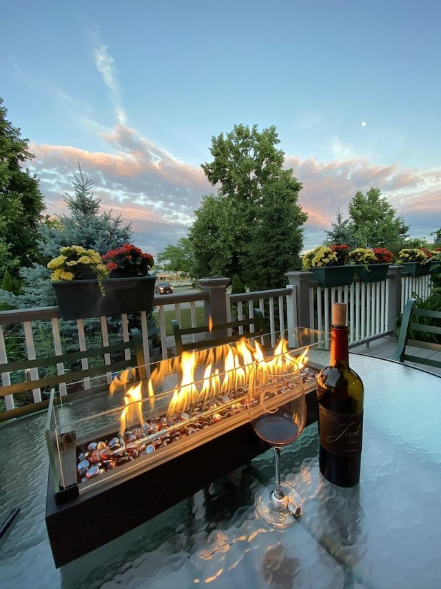 deck at dusk featuring an outdoor fire pit