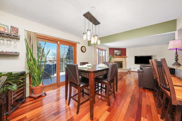 dining area with a brick fireplace and hardwood / wood-style floors