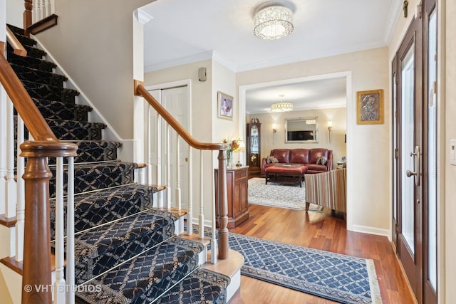 entrance foyer with ornamental molding, baseboards, plenty of natural light, and wood finished floors