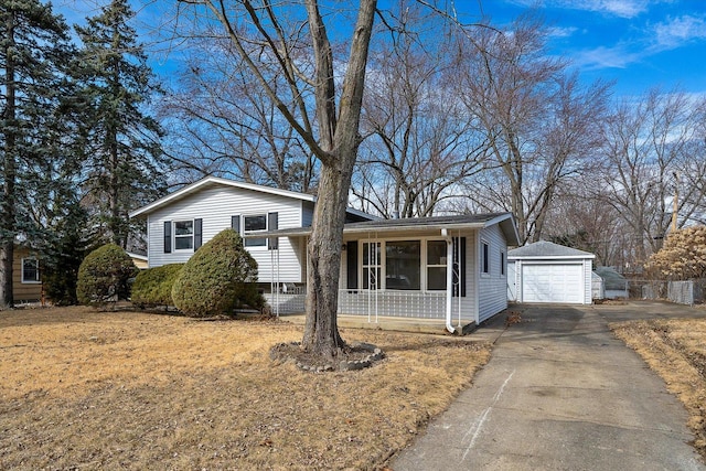 split level home featuring driveway, a detached garage, and an outdoor structure