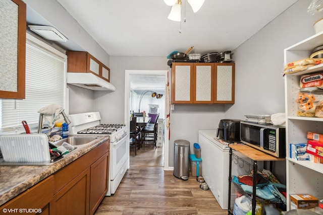 kitchen featuring ceiling fan, wood-type flooring, and white gas range oven