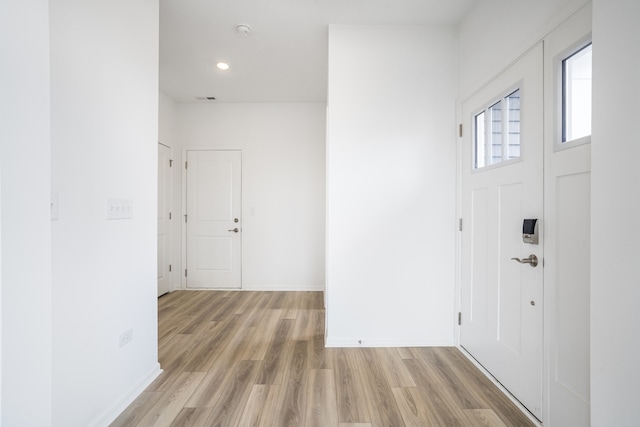 foyer entrance featuring light wood-type flooring, visible vents, and baseboards