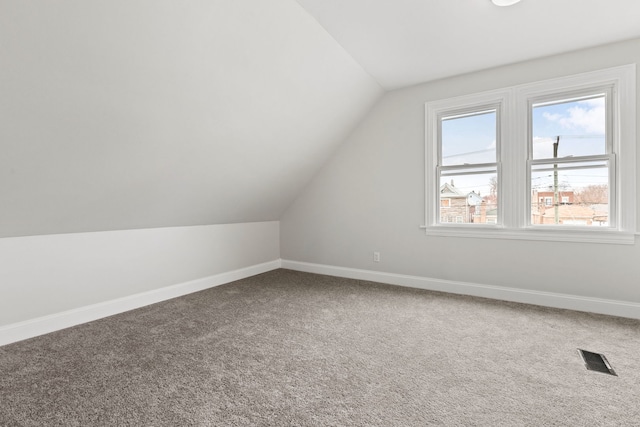 bonus room with baseboards, visible vents, and carpet floors