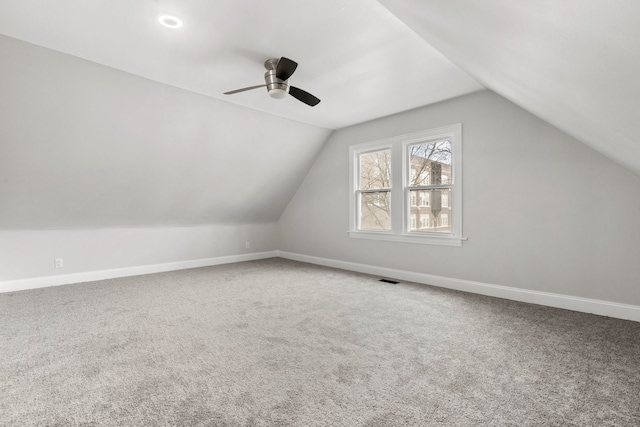 bonus room featuring vaulted ceiling, baseboards, carpet floors, visible vents, and a ceiling fan