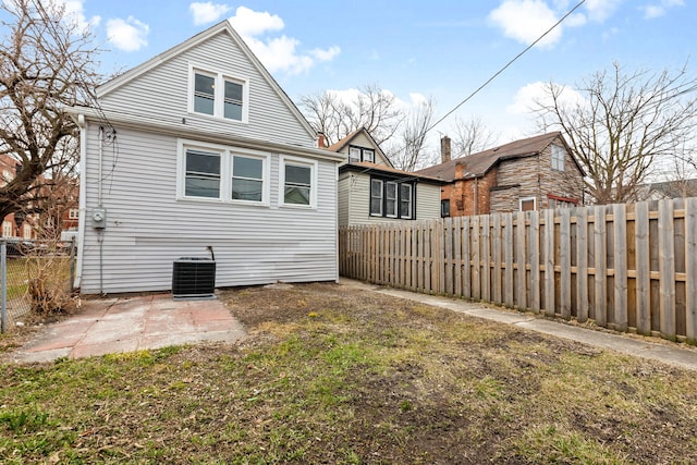 back of house with central air condition unit, a fenced backyard, and a patio area