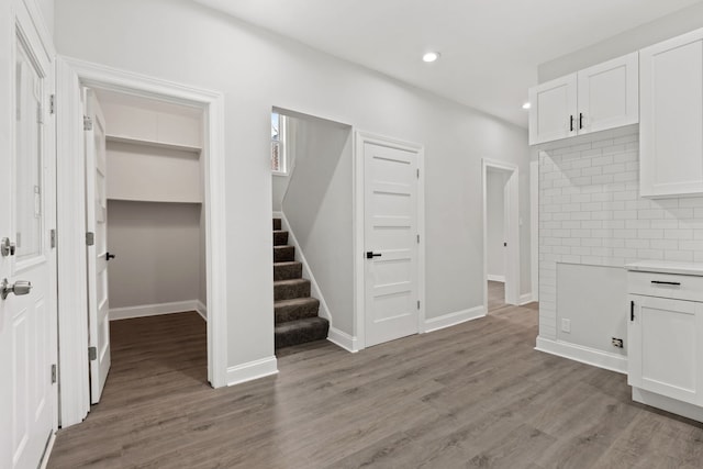interior space featuring stairs, baseboards, light wood finished floors, and recessed lighting