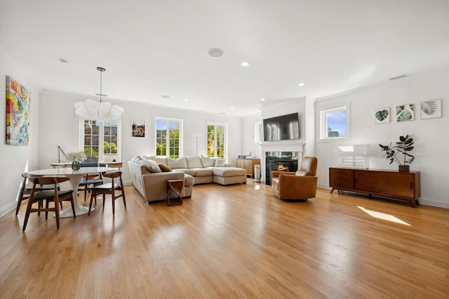 living room featuring crown molding and light hardwood / wood-style flooring