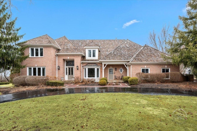 view of front of home featuring brick siding and a front yard