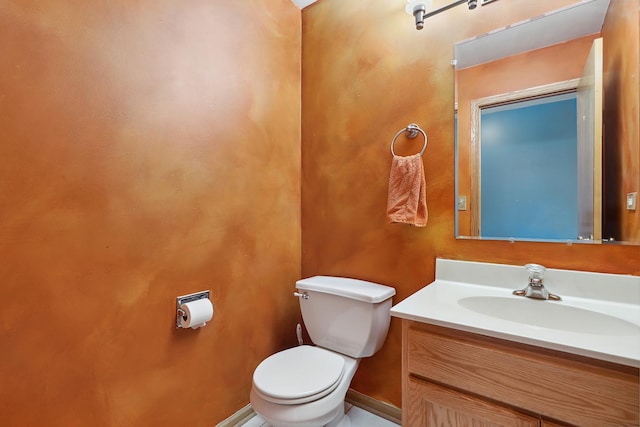 bathroom featuring vanity, toilet, and baseboards