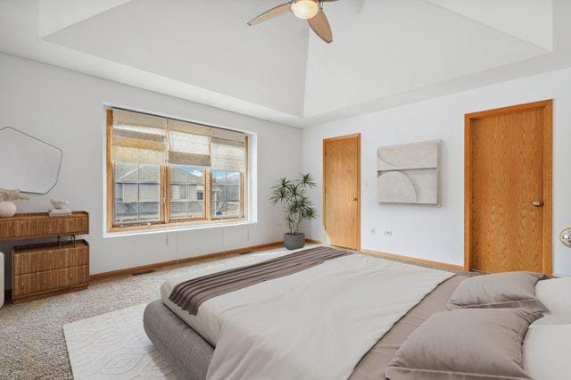 bedroom with high vaulted ceiling, baseboards, a ceiling fan, and light colored carpet