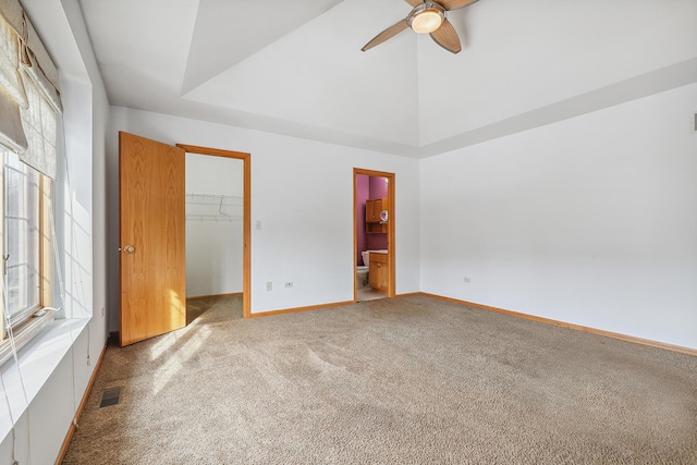 unfurnished bedroom featuring carpet, a walk in closet, multiple windows, and visible vents