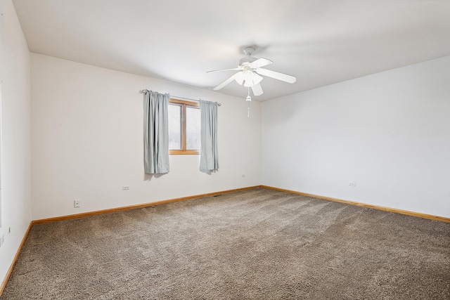 carpeted spare room featuring ceiling fan and baseboards