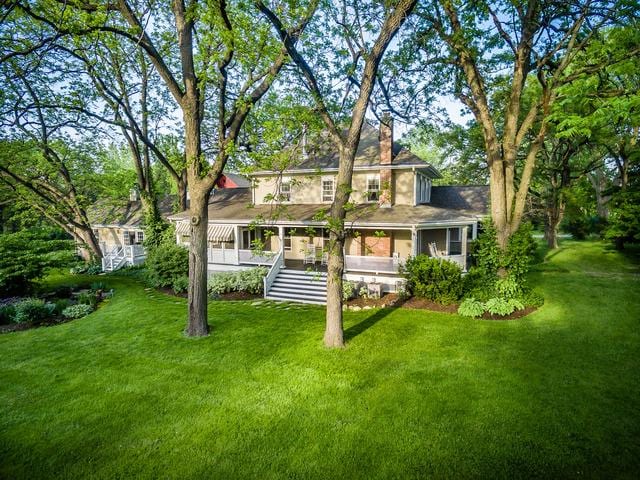 back of property with stairs, a yard, and a chimney