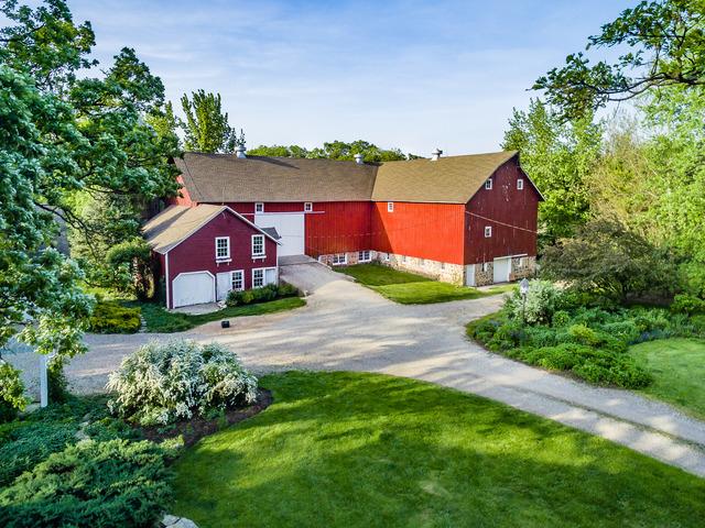 view of front of property with driveway, a front yard, a barn, and an outdoor structure