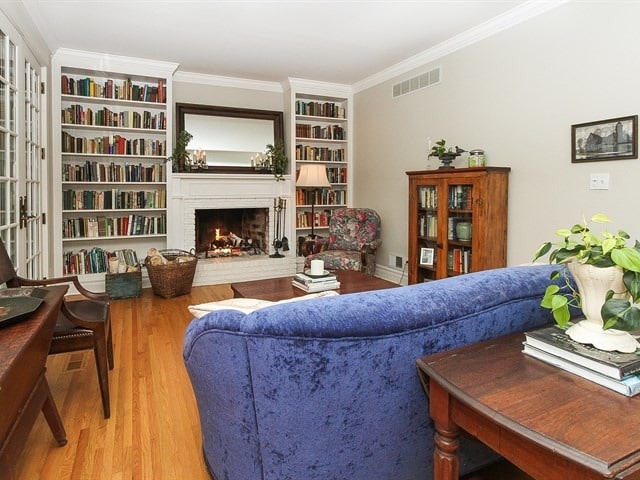44W906 Berner Rd, Hampshire, IL 60140 - living room featuring ornamental molding, a brick fireplace, wood finished floors, and visible vents