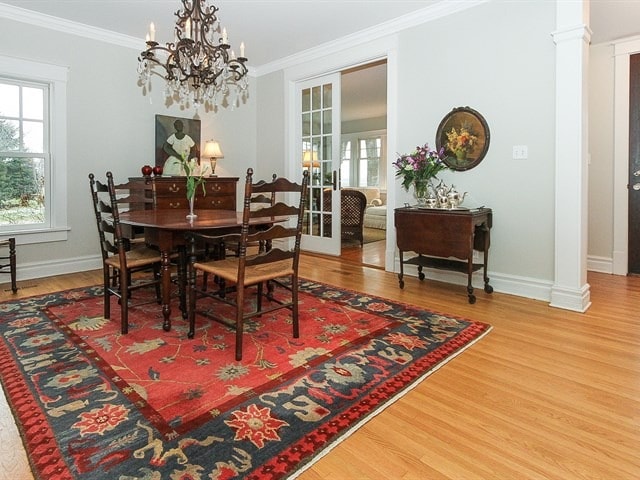44W906 Berner Rd, Hampshire, IL 60140 - dining area with crown molding, wood finished floors, baseboards, decorative columns, and an inviting chandelier