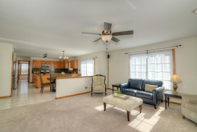 living room with ceiling fan with notable chandelier and light carpet